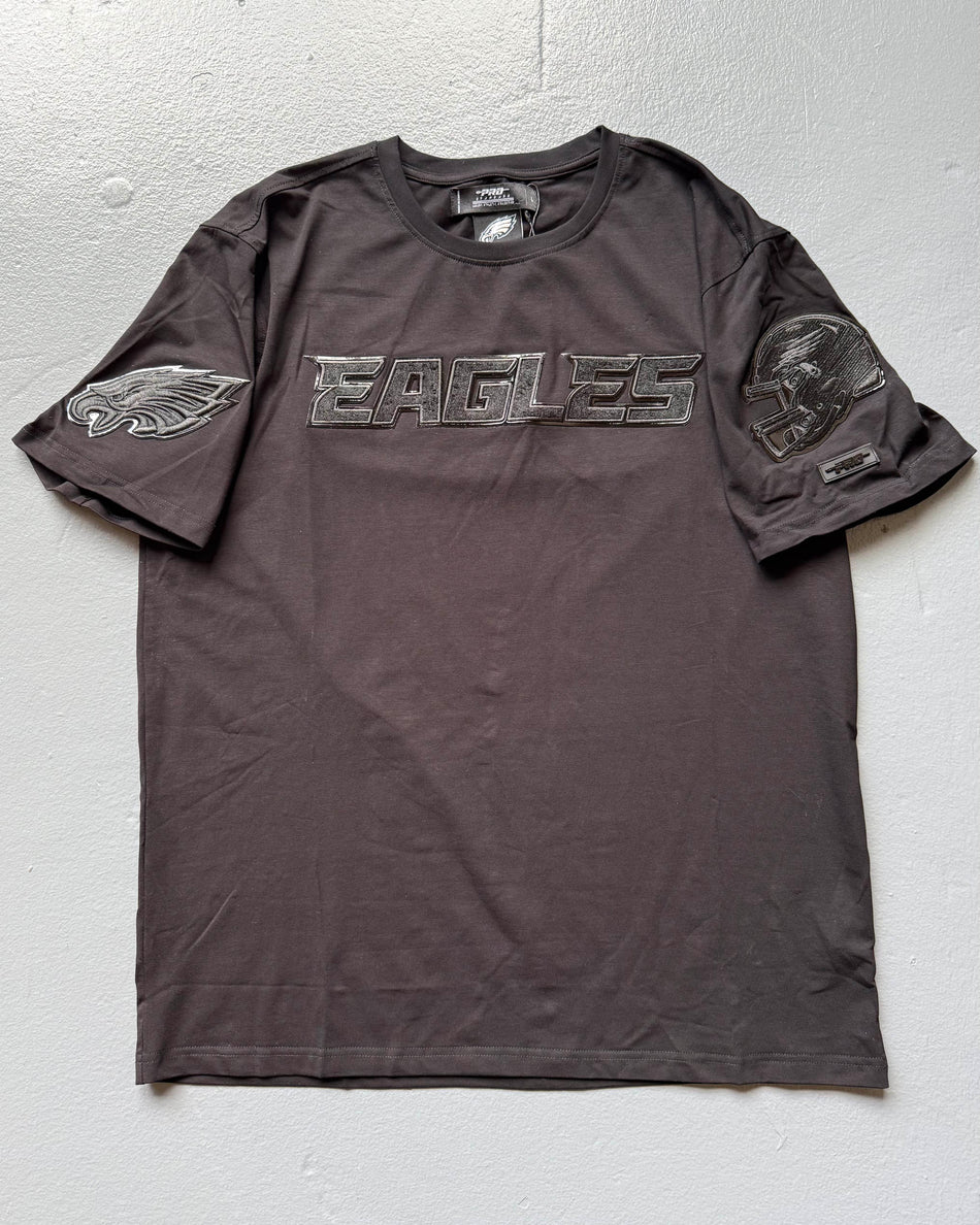 Black T-shirt with 'EAGLES' text and shoulder logos on a light gray background