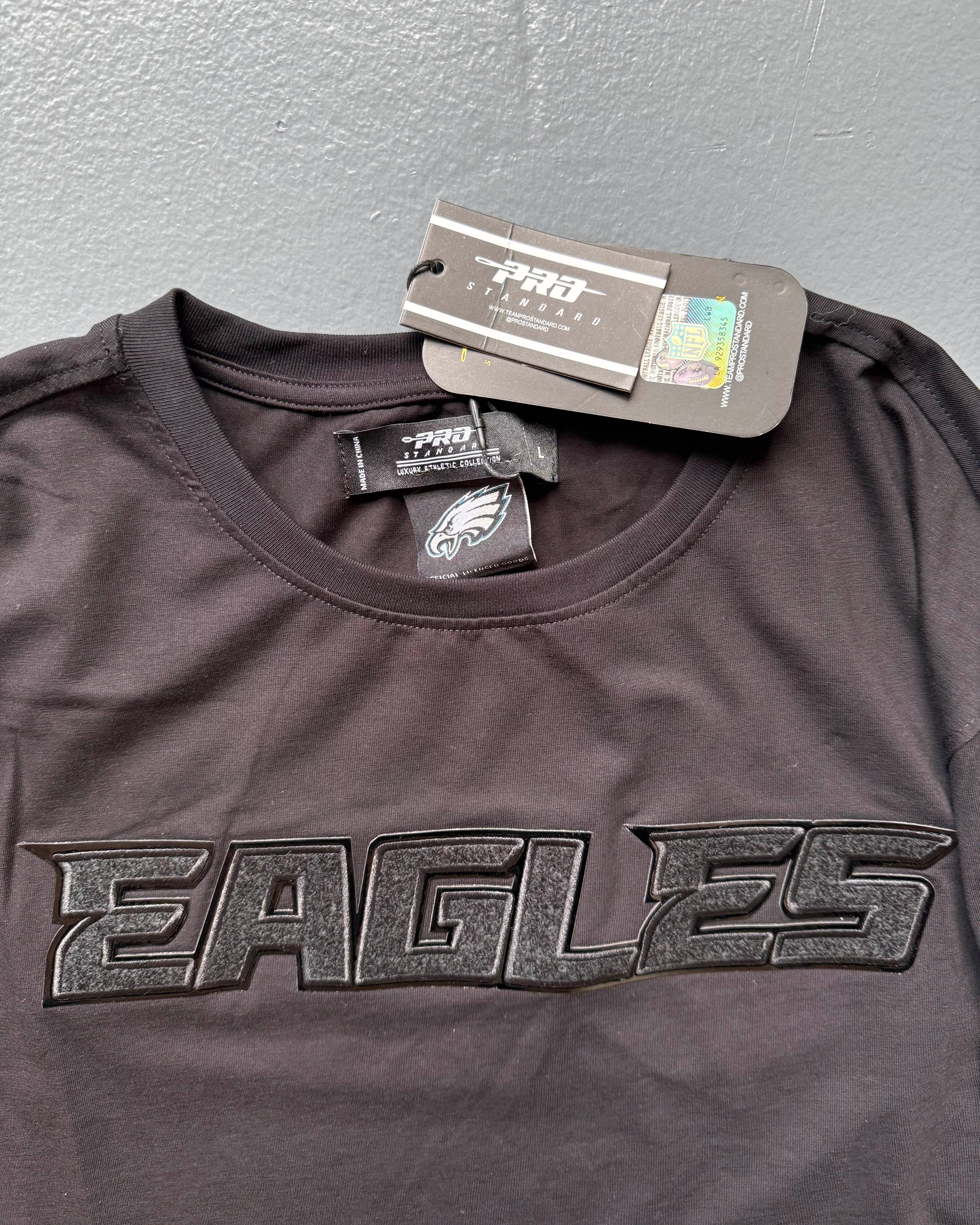 Black sports jersey with 'EAGLES' text and brand tags on a gray background