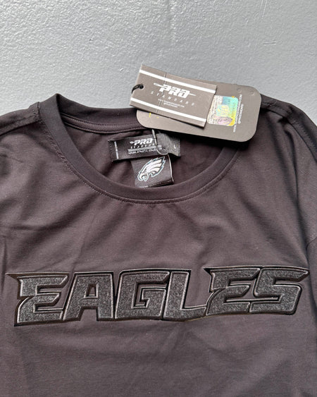 Black sports jersey with 'EAGLES' text and brand tags on a gray background